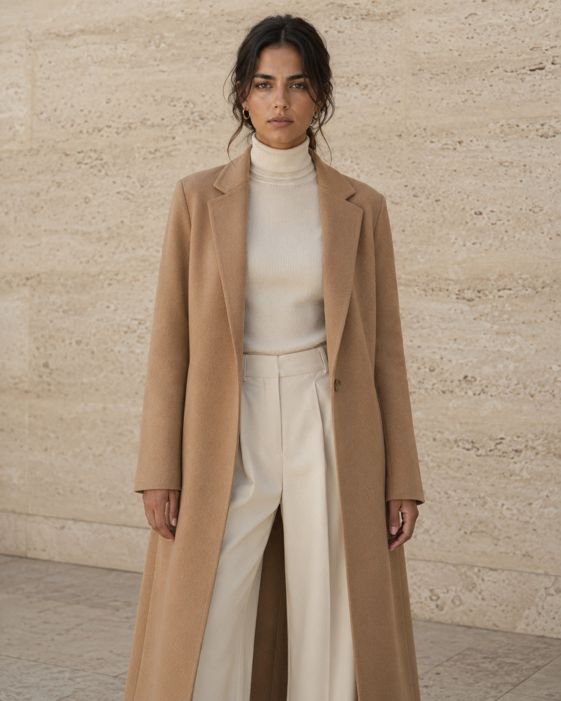 Abrigo de lana camel largo, abierto sobre punto y pantalón crudo